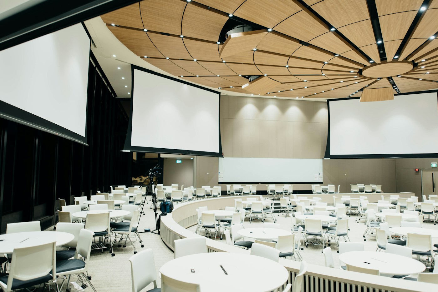 Conference venue set with seating, projection screens, and audiovisual equipment