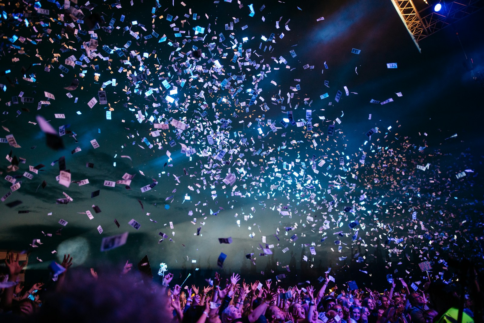 Confetti and blue stage lighting above a live concert audience